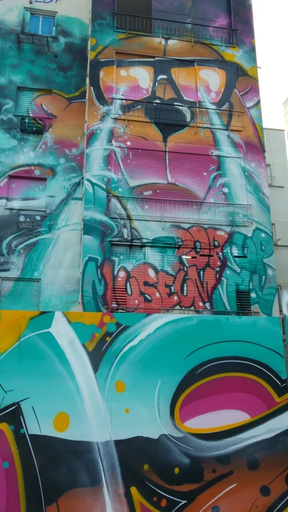 The bear mural and graffiti fence share a continuous palette.