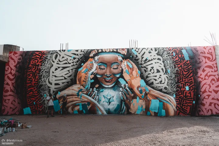 The completed mural with two artists showing its scale